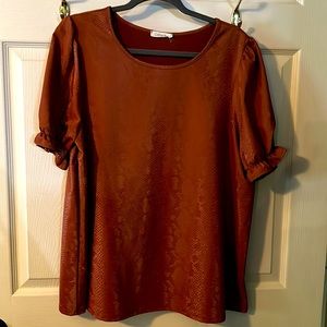 The shirt feels like leather. Very cute with jeans or dress slacks.